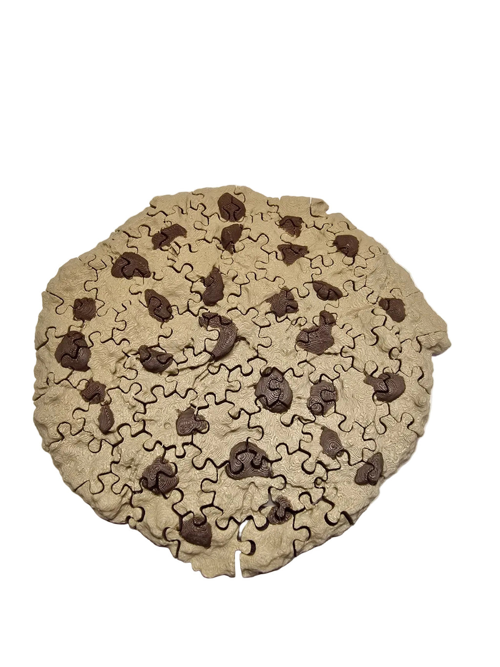 Jigsaw puzzle shaped like a cookie with chocolate chips on a wooden surface