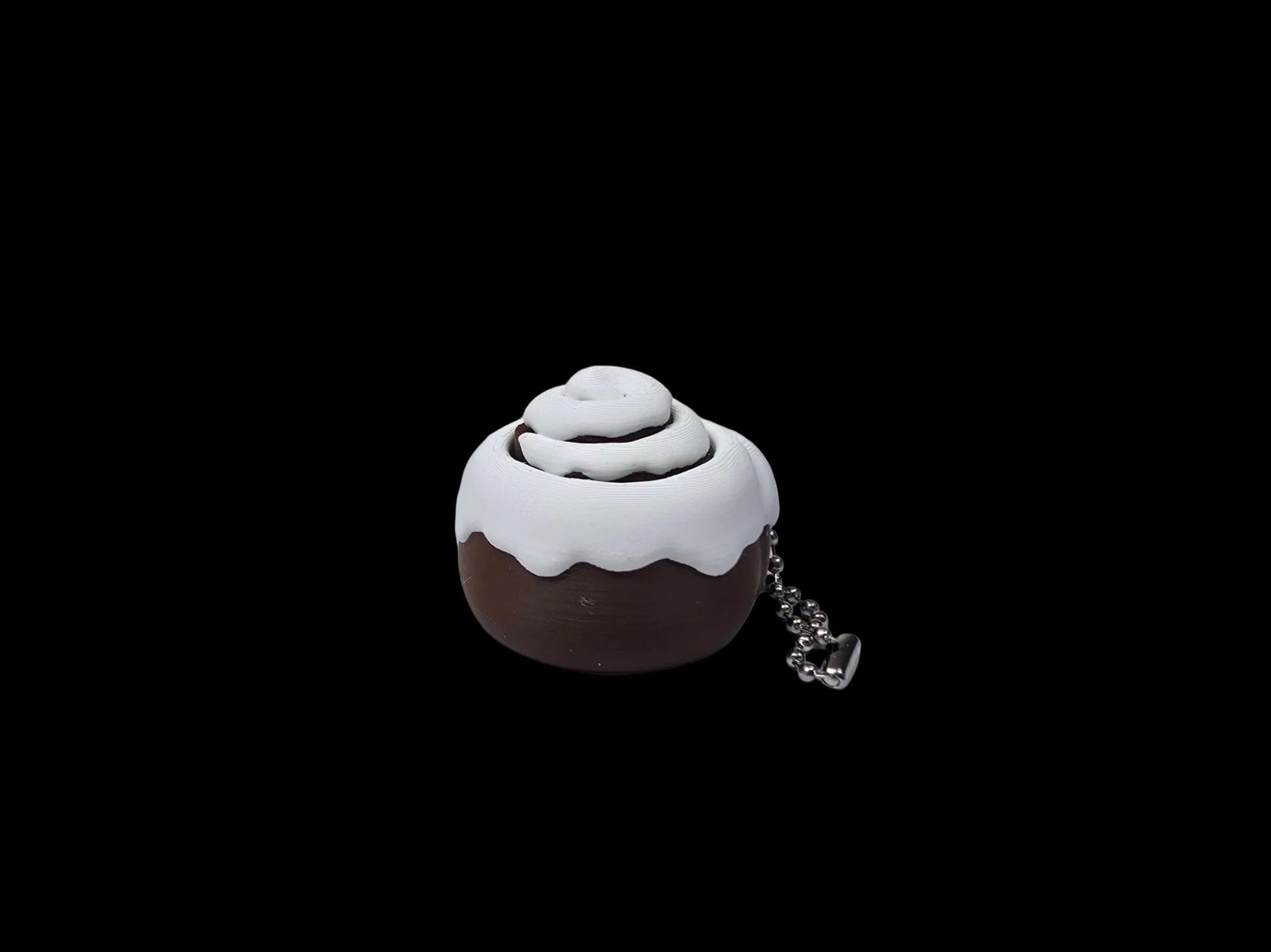 Cinnamon roll-shaped keychain on a textured surface